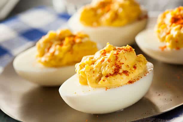 Four deviled eggs dusted with paprika